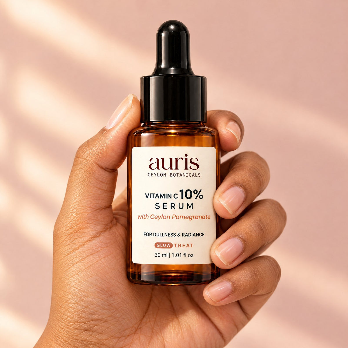 Auris GLOW Vitamin C 10% Serum held in hand, label facing the camera